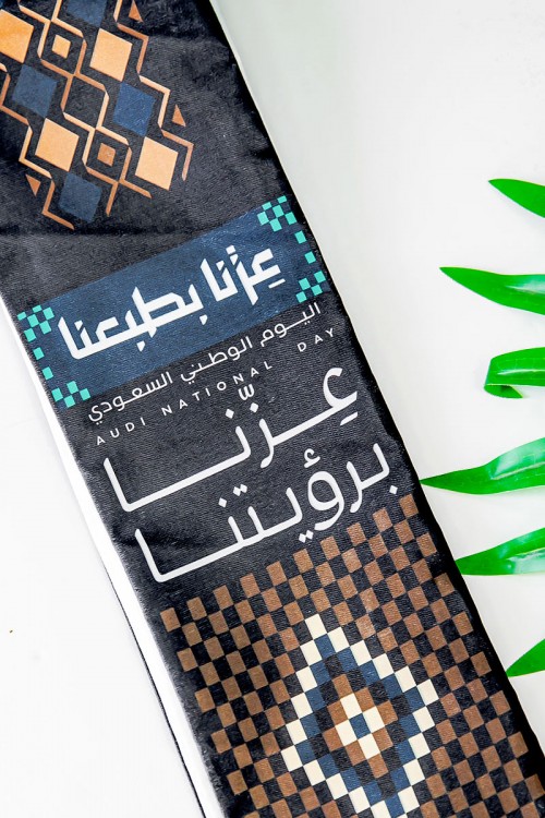 وشاح لون أسود لليوم الوطني بشعار عزنا بطبعنا