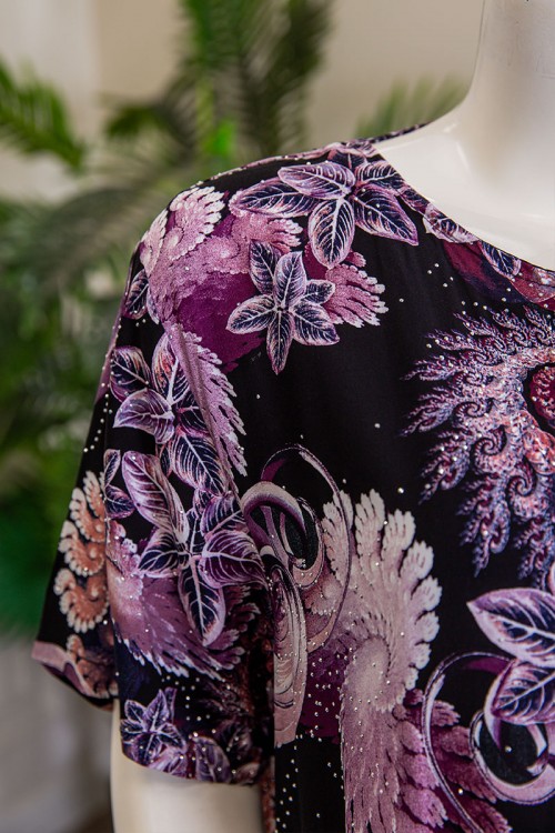 قميص نسائي طويل لون أسود مشجر باللون الموف مزين بفصوص ياقة دائرية بأزرار من الأمام و أكمام قصيرة