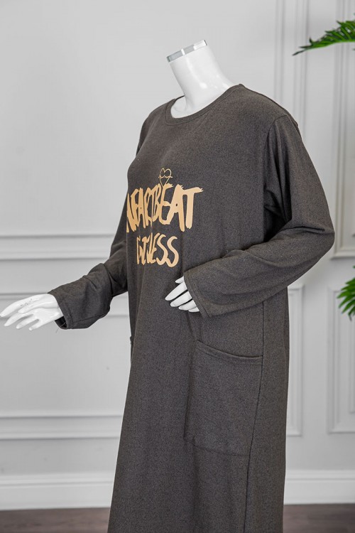 قميص نسائي شتوي طويل لون زيتي مزين بكتابات و رسومات من الأمام ياقة دائرية و جيوب من الجانبين و أكمام طويلة