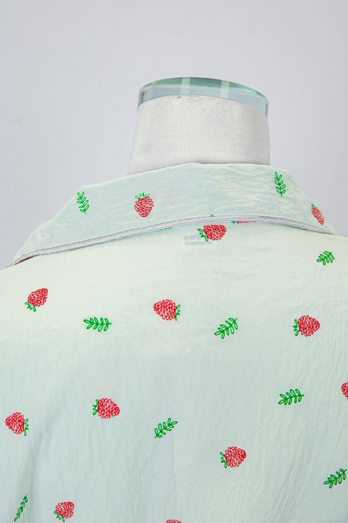 بجامة نسائية قطعتين لون تفاحي مزينة برسومات بلوزة بياقة مطوية و جيب و أزرار من الأمام بأكمام قصيرة مع بنطلون طويل