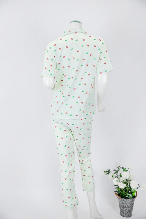 بجامة نسائية قطعتين لون تفاحي مزينة برسومات بلوزة بياقة مطوية و جيب و أزرار من الأمام بأكمام قصيرة مع بنطلون طويل