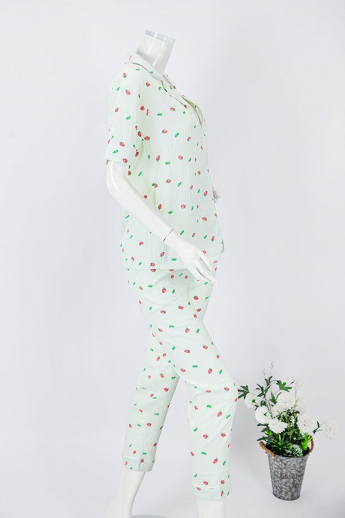 بجامة نسائية قطعتين لون تفاحي مزينة برسومات بلوزة بياقة مطوية و جيب و أزرار من الأمام بأكمام قصيرة مع بنطلون طويل