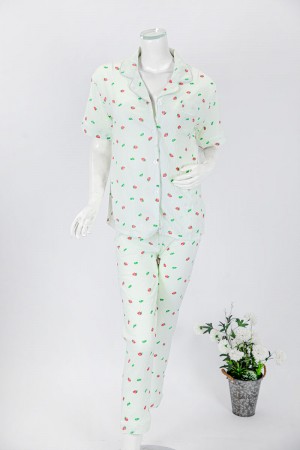 بجامة نسائية قطعتين لون تفاحي مزينة برسومات بلوزة بياقة مطوية و جيب و أزرار من الأمام بأكمام قصيرة مع بنطلون طويل 