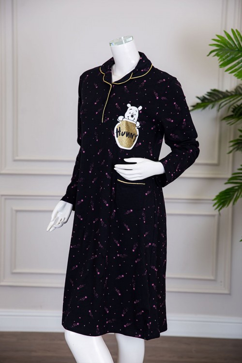 قميص نسائي شتوي ميدي لون أسود مزين بنجوم وردية و بكتابات رسومات و جيب من الأمام ياقة مطوية بأزرار و بأكمام طويلة