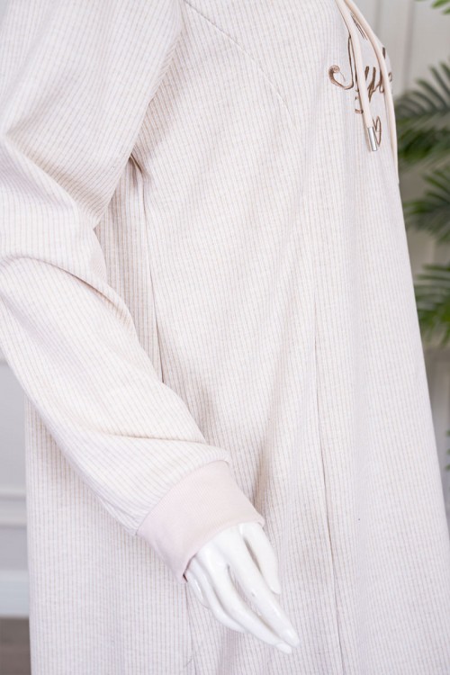 قميص نسائي شتوي طويل لون بيج فاتح مزين بكتابات ياقة بقبعة متصلة برباط و بأكمام طويلة