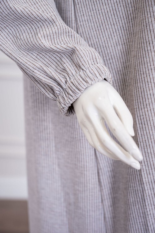 قميص نسائي شتوي طويل لون بيج مزين بكتابات من الأمام ياقة دائرية بأزرار و بأكمام طويلة