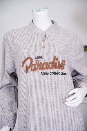 قميص نسائي شتوي طويل لون بيج مزين بكتابات من الأمام ياقة دائرية بأزرار و بأكمام طويلة 