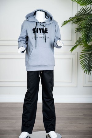 طقم قطعتين ولادي شتوي بلوزة لون سماوي مزينة بكتابات من الأمام بقبعة متصلة برباط و بجيوب و أكمام طويلة و بنطلون طويل لون أسود برباط في الخصر 