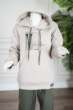 طقم قطعتين ولادي شتوي بلوزة لون بيج مزينة بكتابات من الأمام بقبعة متصلة برباط و بجيوب و أكمام طويلة و بنطلون طويل لون زيتي برباط في الخصر 