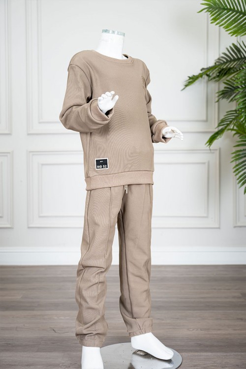 طقم قطعتين ولادي شتوي لون بيج غامق مزين بكتابات من الأمام بلوزة ياقة دائرية بأكمام طويلة و بنطلون طويل برباط في الخصر