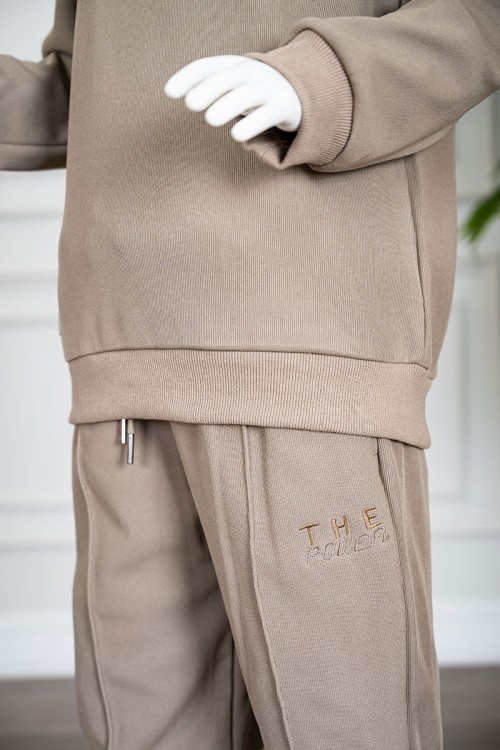 طقم قطعتين ولادي شتوي لون بيج غامق مزين بكتابات من الأمام بلوزة ياقة دائرية بأكمام طويلة و بنطلون طويل برباط في الخصر