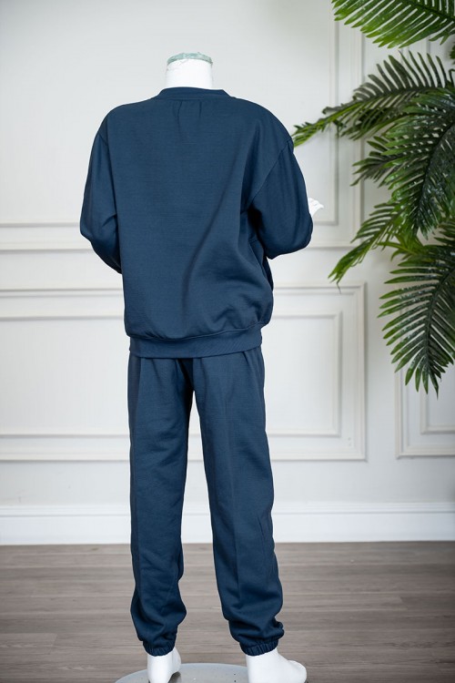 طقم قطعتين ولادي شتوي لون كحلي مزين بكتابات من الأمام بلوزة ياقة دائرية بجيوب و أكمام طويلة و بنطلون طويل بطبعات