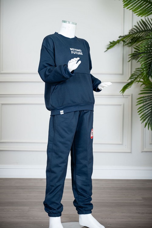 طقم قطعتين ولادي شتوي لون كحلي مزين بكتابات من الأمام بلوزة ياقة دائرية بجيوب و أكمام طويلة و بنطلون طويل بطبعات