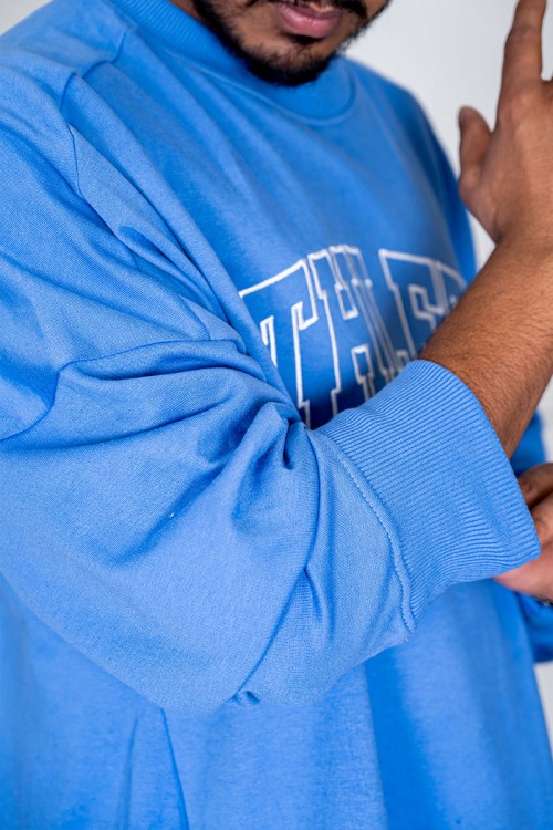 بلوفر رجالي لون سماوي ياقة دائرية مزين بكتابات من الأمام و بأكمام طويلة