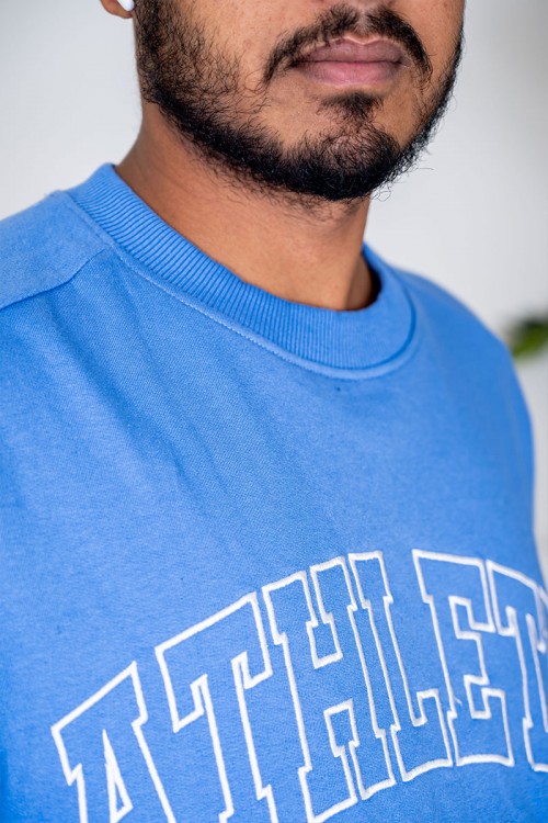 بلوفر رجالي لون سماوي ياقة دائرية مزين بكتابات من الأمام و بأكمام طويلة