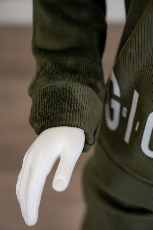 طقم بناتي شتوي قطعتين لون زيتي هودي بقبعة متصلة برباط و أكمام طويلة مزين بكتابات باللون الأبيض مع بنطلون طويل برباط في الخصر و جيوب من الجانبين