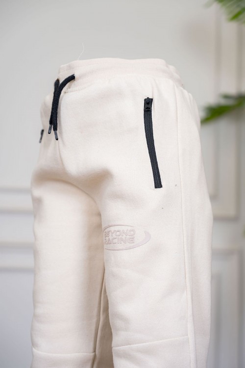 بنطلون ولادي لون بيج فاتح برباط في الخصر وجيوب في الجانبين بساحب باللون الأسود و زم أسفل البنطلون