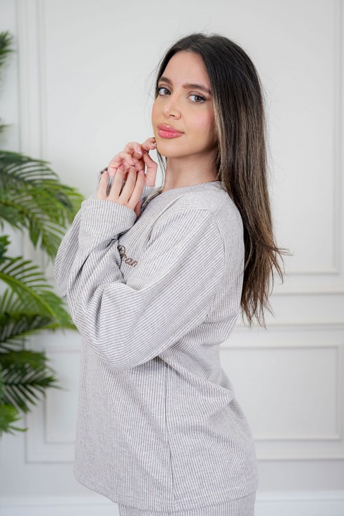 بيجاما نسائية قطعتين لون بيج مزينة بكتابات من الأمام ياقة دائرية بأزرار و بأكمام طويلة مع بنطلون طويل برباط في الخصر