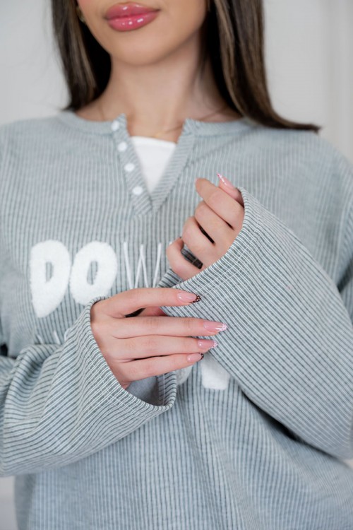 بيجاما نسائية قطعتين لون زيتي فاتح مزينة بكتابات من الأمام ياقة دائرية بأزرار و بأكمام طويلة مع بنطلون طويل برباط في الخصر