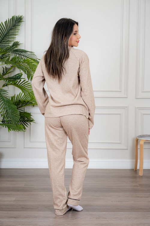 بيجاما نسائية قطعتين لون بيج مزينة بكتابات وخطوط باللون الأسود من الأمام ياقة دائرية و بأكمام طويلة مع بنطلون طويل