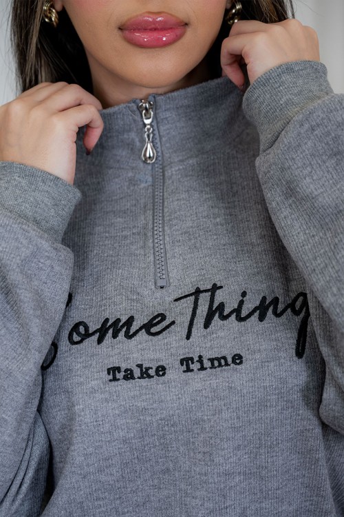 بيجاما نسائية قطعتين لون رمادي مزينة بكتابات من الأمام ياقة عالية بسحاب و بأكمام طويلة مع بنطلون طويل برباط في الخصر