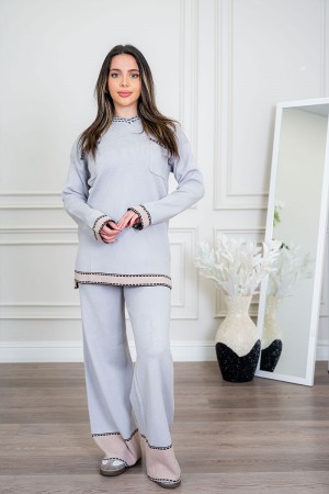 طقم تريكو نسائي شتوي قطعتين لون رمادي فاتح مزين من الأطراف باللون البيج الفاتح ياقة دائرية بجيوب من الأمام مع بنطلون طويل