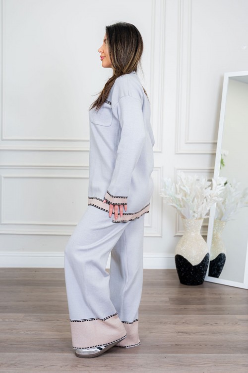 طقم تريكو نسائي شتوي قطعتين لون رمادي فاتح مزين من الأطراف باللون البيج الفاتح ياقة دائرية بجيوب من الأمام مع بنطلون طويل