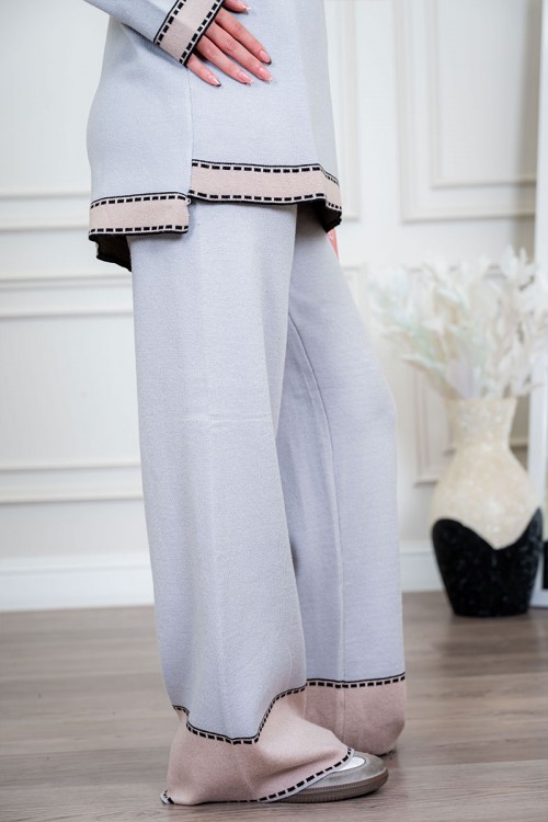 طقم تريكو نسائي شتوي قطعتين لون رمادي فاتح مزين من الأطراف باللون البيج الفاتح ياقة دائرية بجيوب من الأمام مع بنطلون طويل