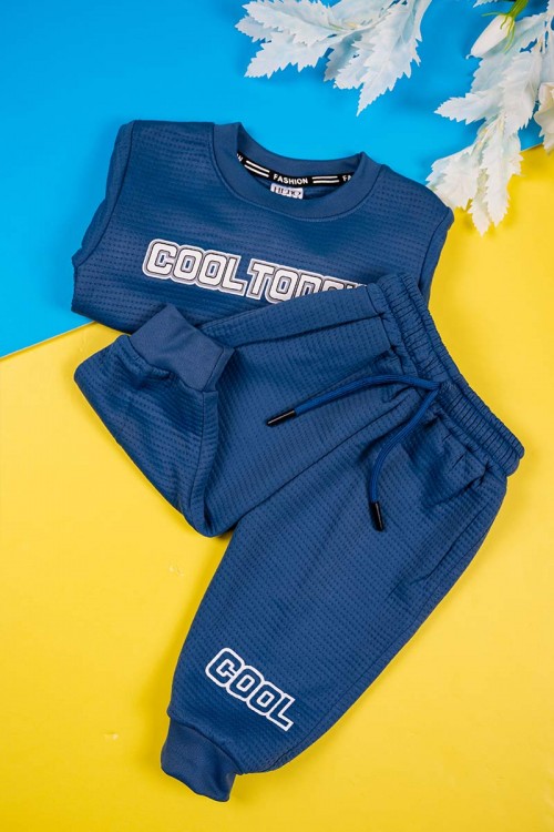 طقم قطعتين ولادي لون كحلي مزين بكتابات بأكمام طويلة مع بنطلون طويل برباط في الخصر و زم في الأطراف