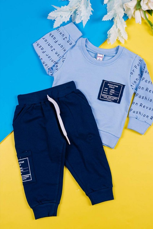 طقم قطعتين ولادي بلوزة لون سماوي مزينة بكتابات من الأمام و الخلف و بأكمام طويلة مع بنطلون كحلي طويل برباط في الخصر و زم في الأطراف