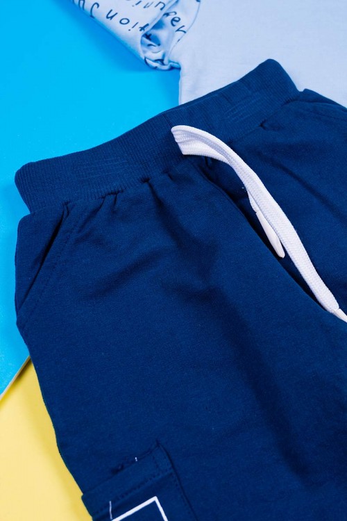 طقم قطعتين ولادي بلوزة لون سماوي مزينة بكتابات من الأمام و الخلف و بأكمام طويلة مع بنطلون كحلي طويل برباط في الخصر و زم في الأطراف