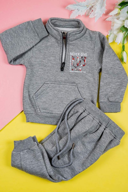 طقم قطعتين ولادي لون رمادي بلوزة بياقة عالية و بسحاب مزينة بكتابات و بجيب الكنغر من الأمام و بأكمام طويلة مع بنطلون طويل برباط في الخصر و زم في الأطراف