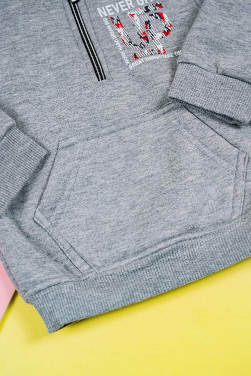 طقم قطعتين ولادي لون رمادي بلوزة بياقة عالية و بسحاب مزينة بكتابات و بجيب الكنغر من الأمام و بأكمام طويلة مع بنطلون طويل برباط في الخصر و زم في الأطراف