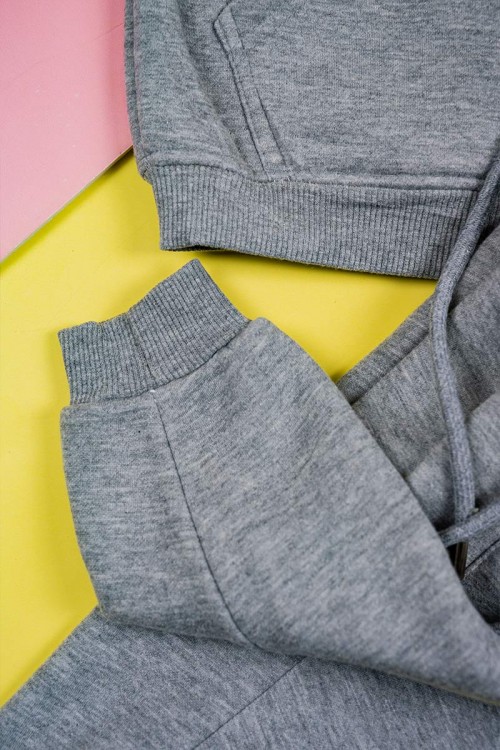 طقم قطعتين ولادي لون رمادي بلوزة بياقة عالية و بسحاب مزينة بكتابات و بجيب الكنغر من الأمام و بأكمام طويلة مع بنطلون طويل برباط في الخصر و زم في الأطراف