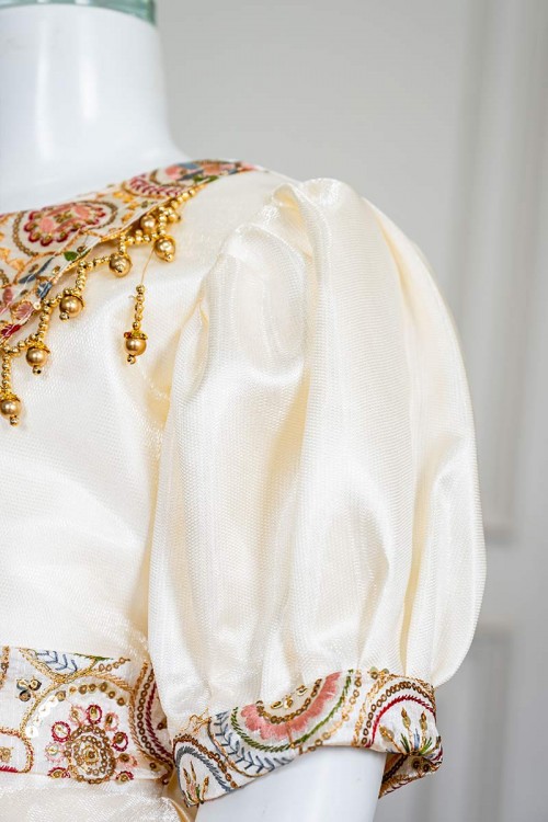 فستان بناتي طويل لون بيج فاتح مزين بتطريز ملون من الياقة و أطراف الأكمام و بحزام في الخصر