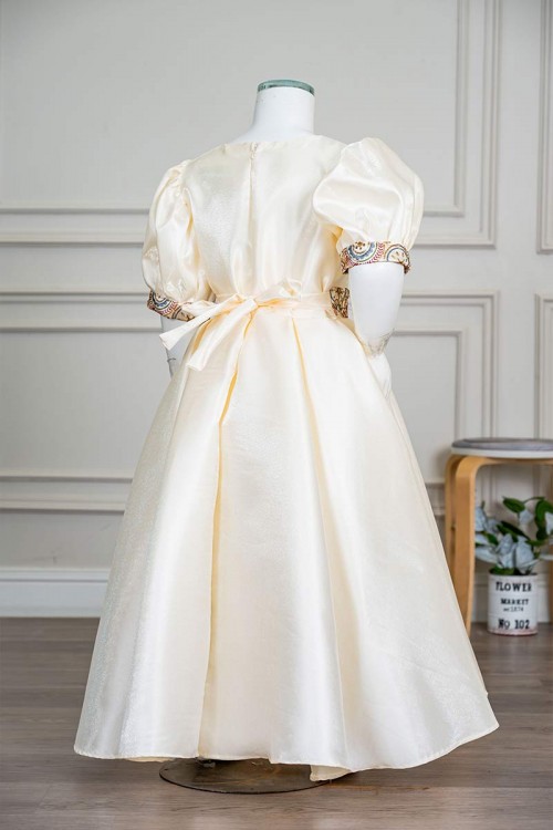 فستان بناتي طويل لون بيج فاتح مزين بتطريز ملون من الياقة و أطراف الأكمام و بحزام في الخصر