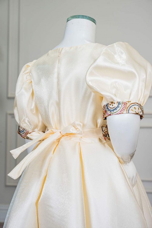 فستان بناتي طويل لون بيج فاتح مزين بتطريز ملون من الياقة و أطراف الأكمام و بحزام في الخصر