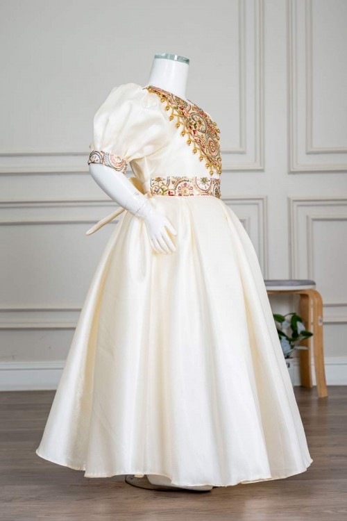 فستان بناتي طويل لون بيج فاتح مزين بتطريز ملون من الياقة و أطراف الأكمام و بحزام في الخصر