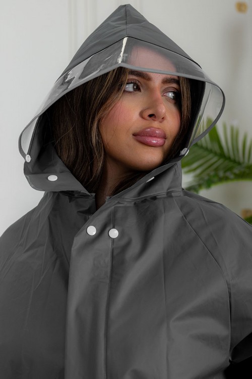 بالطو مطر نسائي لون رصاصي بقبعة متصلة بأزرار و سحاب و جيوب من الأمام و بأكمام طويلة