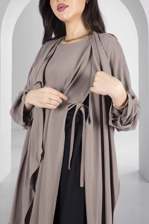 عباية ملونة أنيقة لون بيج قماش سي واي بقطعة لف اضافية من الداخل برباط على الخصر و أزرار قفل من الكتف بأكمام مزينة بأزرار كبيرة مع طرحة سادة