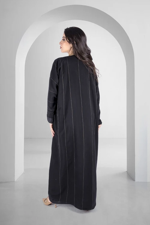 عباية سوداء انيقة أزرار قفل امامية خطوط طولية مطرزة باللون الذهبي اللامع و أكمام ضيقة مثنية بقماش مشجر انيق