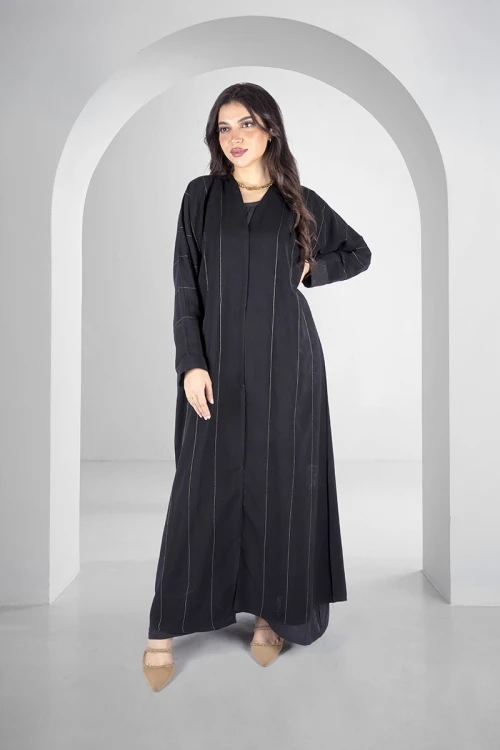 عباية سوداء انيقة أزرار قفل امامية خطوط طولية مطرزة باللون الذهبي اللامع و أكمام ضيقة مثنية بقماش مشجر انيق