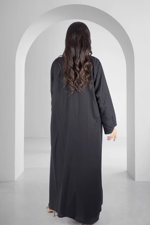 عباية سوداء أنيقة مفتوحة من الامام على شكل طبقة مثنية بأكمام ضيقة مطرزة بشكب دائري ناعم وأنيق
