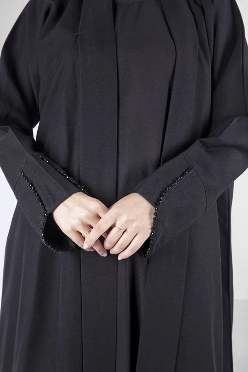 عباية سوداء أنيقة مفتوحة من الامام على شكل طبقة مثنية بأكمام ضيقة مطرزة بشكب دائري ناعم وأنيق