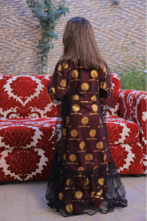 فستان يوم التأسيس بناتي ثلاث قطع لون عودي عليه شعار يوم التأسيس باللون الذهبي مع عباية شيفون اسود أطراف ذهبية و طرحة