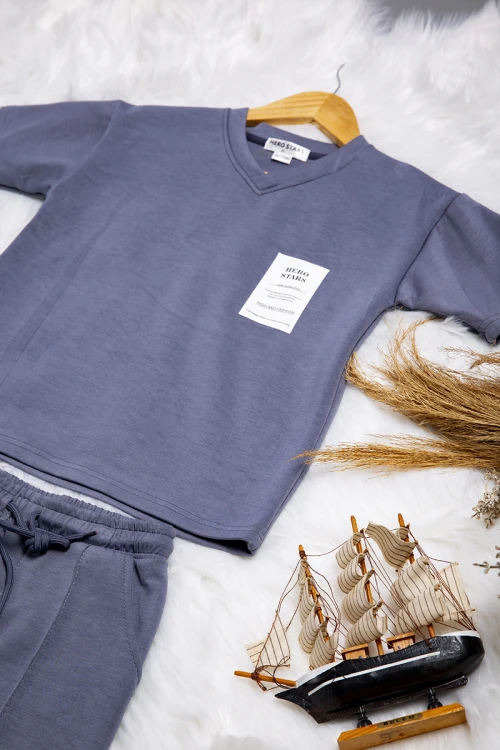 طقم ولادي قطعتين تيشرت بشعار من الأمام و كتابات من الخلف و بنطلون بجيوب ورباط من الخصر