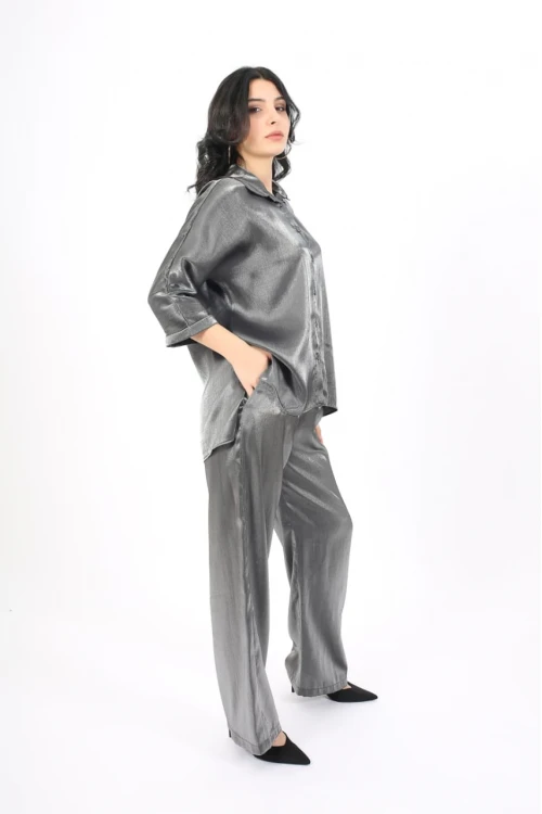 طقم نسائي أنيق قطعتين لون رمادي لامع قميص أكمام طويلة بياقة و أزرار أمامية و بنطلون طويل واسع مطاط ورباط من الخصر