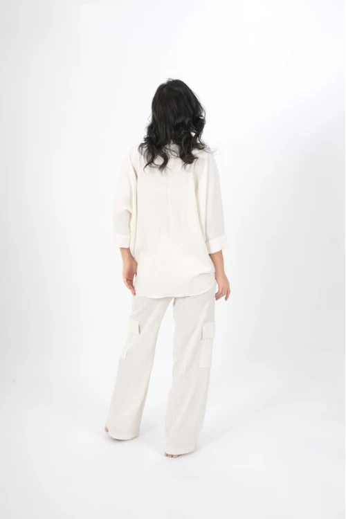 طقم نسائي أنيق قطعتين لون ابيض قميص أكمام طويلة بياقة و أزرار أمامية و بنطلون واسع طويل بجيوب