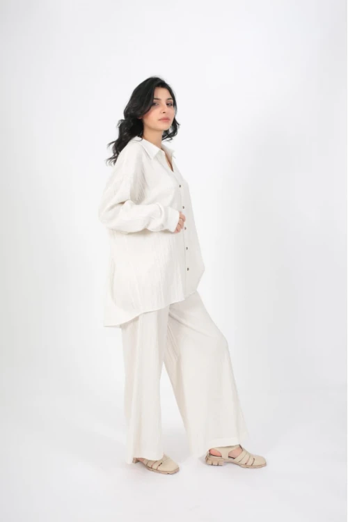 طقم نسائي أنيق قطعتين لون ابيض قميص أكمام طويلة بياقة و أزرار أمامية و بنطلون واسع طويل بجيوب