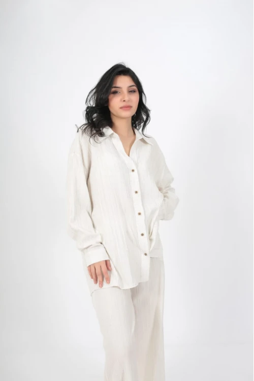 طقم نسائي أنيق قطعتين لون ابيض قميص أكمام طويلة بياقة و أزرار أمامية و بنطلون واسع طويل بجيوب